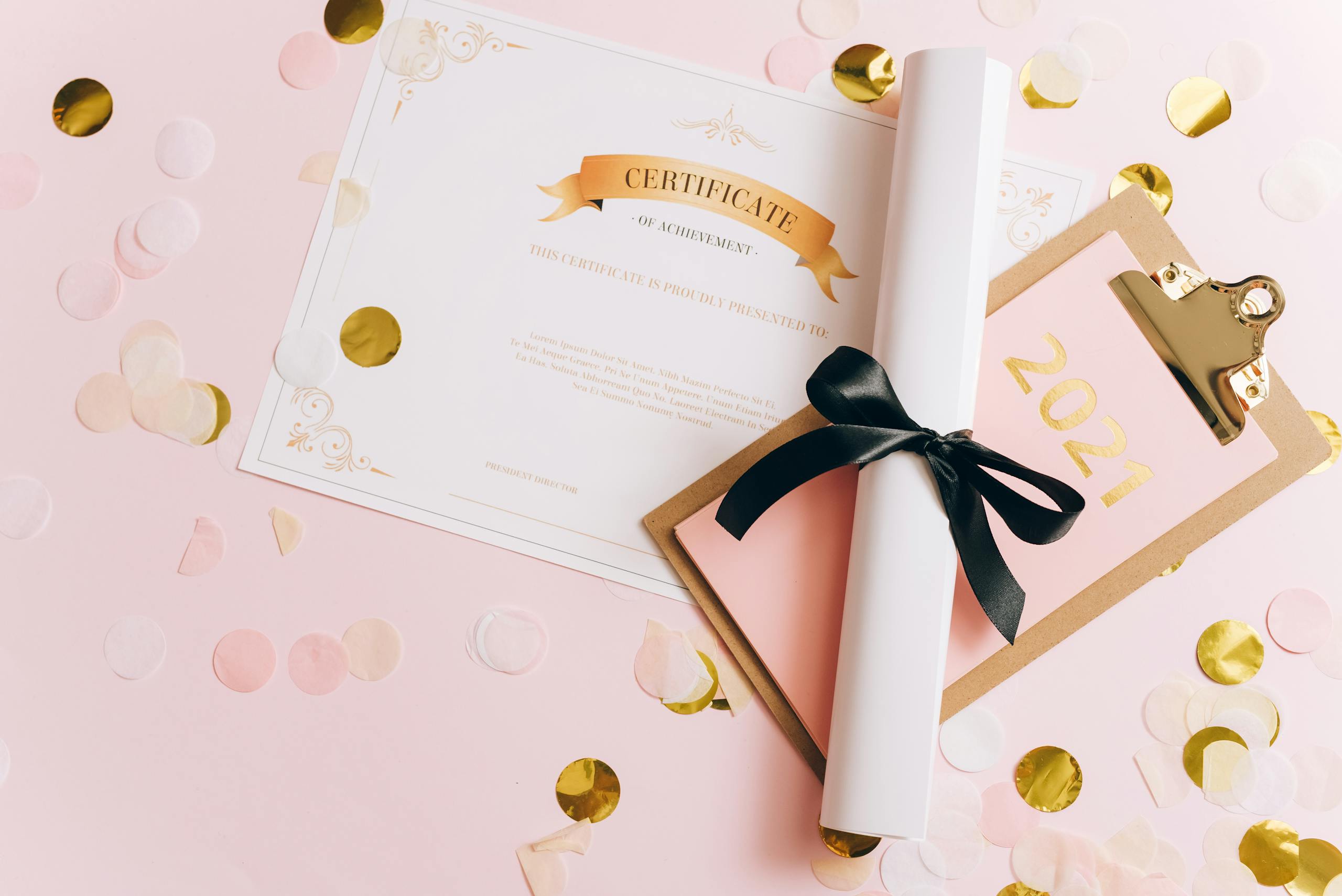 A rolled-up diploma with a certificate of achievement surrounded by confetti, perfect for graduation themes.